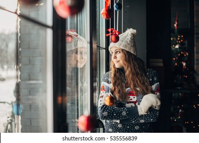 Beautiful Brunette In Christmas Sweater Looking Out The Window