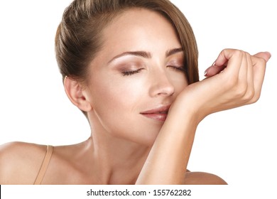 beautiful brunette female model smelling her perfume on white