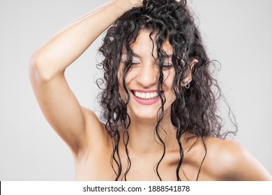 Beautiful brunette girl with long wet hair, studio portrait. Very happy smiling expression.
