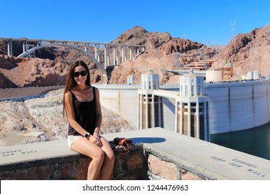 Beautiful Brunette Girl Model In Glasses Smiling Against The Background Of The Hoover Dam. Arizona Nevada USA. Close Up. 