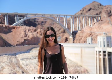 Beautiful Brunette Girl Model In Glasses Smiling Against The Background Of The Hoover Dam. Arizona Nevada USA. Close Up. 