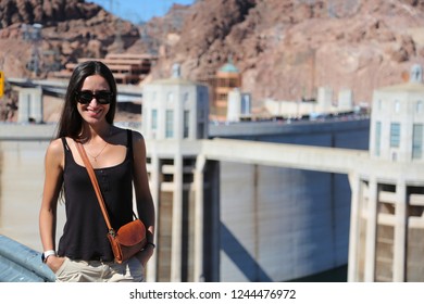 Beautiful Brunette Girl Model In Glasses Smiling Against The Background Of The Hoover Dam. Arizona Nevada USA. Close Up. 