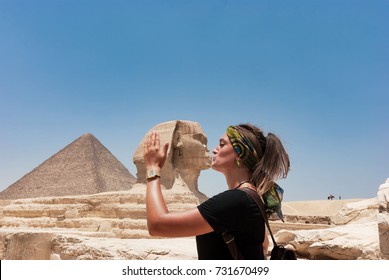Beautiful brunette girl pretending to kiss the sculpture of Giza, Egypt