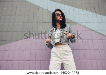 Beautiful Brunette Girl in Sunglasses White Pants and Jeans Jacket