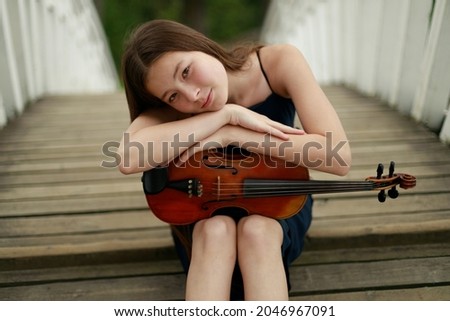 beautiful brunette girl with violin on the bridge. High quality photo