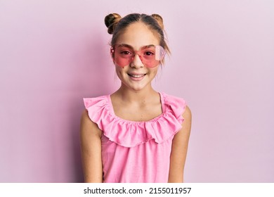 Beautiful Brunette Little Girl Wearing Heart Shaped Sunglasses With A Happy And Cool Smile On Face. Lucky Person. 