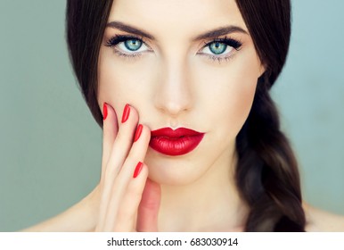 Beautiful  brunette model girl with  long braid hair . Hairstyle  pigtail  . Red lips and nails manicure .