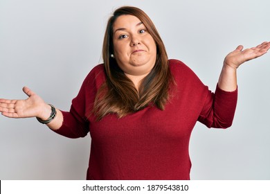 Beautiful Brunette Plus Size Woman Wearing Casual Clothes Clueless And Confused With Open Arms, No Idea And Doubtful Face. 