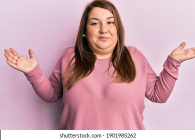 Beautiful Brunette Plus Size Woman Wearing Casual Winter Sweater Clueless And Confused With Open Arms, No Idea And Doubtful Face. 