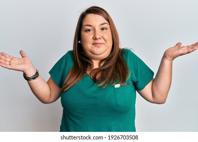 Beautiful Brunette Plus Size Woman Wearing Casual Clothes Clueless And Confused With Open Arms, No Idea And Doubtful Face. 