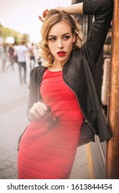 Beautiful Brunette Sexy Spy Agent (killer Or Police) Woman In Leather Jacket And Red Luxury Dress With A Binocular In Her Hand Stalking Someone, To Catch Him In European City.