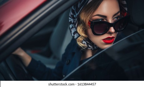 Beautiful brunette sexy spy agent (killer or police) woman in leather jacket and jeans with a gun in her hand driving a car after someone, to catch him.