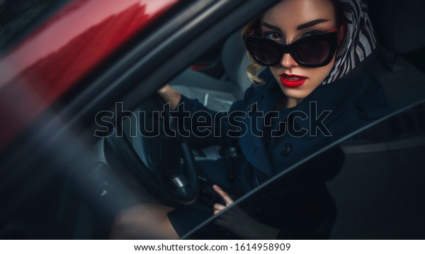 Beautiful brunette sexy spy agent (killer or\
police) woman in leather jacket and jeans with a gun in her hand\
driving a car after someone, to catch\
him.