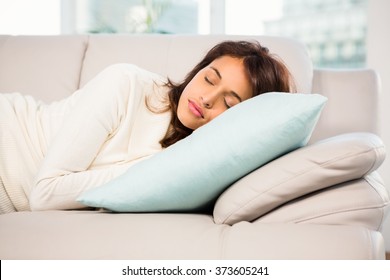 Beautiful brunette taking a nap lying on the couch at home - Shutterstock ID 373605241