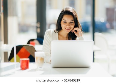 Beautiful Brunette Using Laptop In Cafe