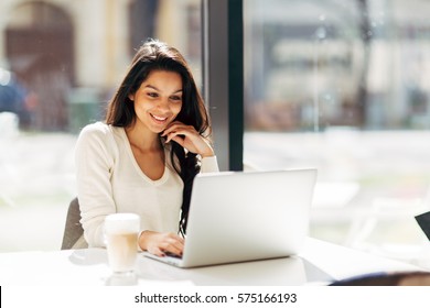 Beautiful Brunette Using Laptop In Cafe