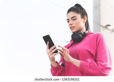 Beautiful Brunette Wearing Sweatshirt Going On A Run And Holding Her Phone With Tracking Miles App, Running And Fitness Concept