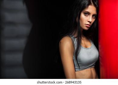 Beautiful Brunette Woman Boxer Near Red Punching Bag