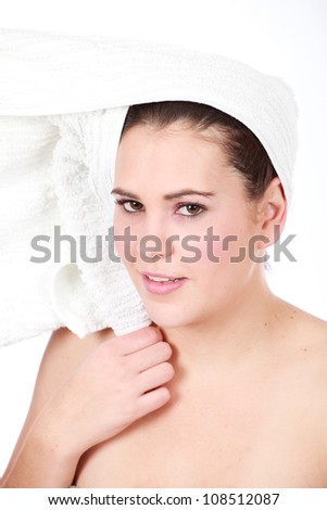 Beautiful brunette woman enjoying a day at the spa with white towel wrapped on her wet washed hair laughing and isolated on white