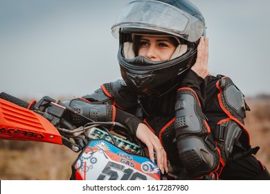 Beautiful Brunette Woman In Motorcycle Outfit. Female Motocross Racer Next To Her Motorcycle. Russia Moscow 20 October 2019