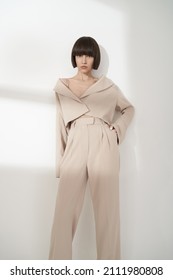 Beautiful brunette woman with natural makeup wear fashion pantsuit. Strict graphic bob haircut.  