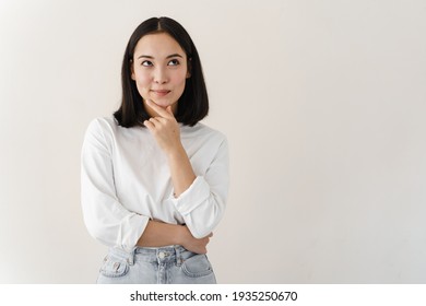 Beautiful Brunette Woman Over Isolated Background With Hand On Chin Thinking About Question, Pensive Expression. Girl With Thoughtful Face. Doubt Concept.