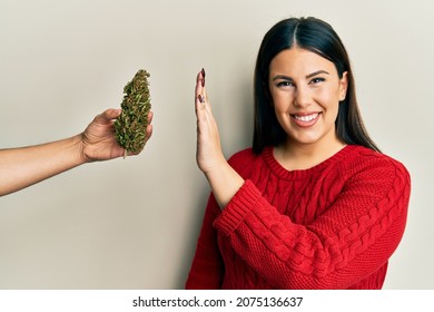 Beautiful Brunette Woman Saying No To Marijuana Herb Smiling With A Happy And Cool Smile On Face. Showing Teeth. 