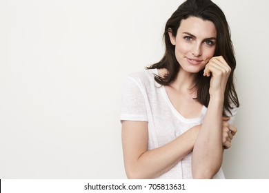Beautiful brunette woman smiling at camera in studio - Shutterstock ID 705813631