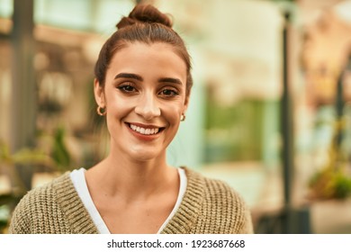 Beautiful brunette woman smiling happy and confident outdoors at the city on a sunny day of autumn