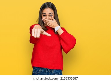 Beautiful Brunette Woman Wearing Casual Winter Sweater Laughing At You, Pointing Finger To The Camera With Hand Over Mouth, Shame Expression 