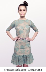 Beautiful Brunette Woman Wearing A Green Lace Dress And Holding Her Hand On Her Waist. Girl Posing Fashion.