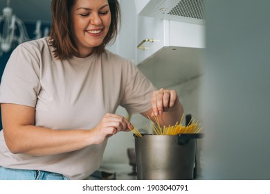 Beautiful Brunette Young Woman Plus Size Body Positive Cooking In Kitchen At Home