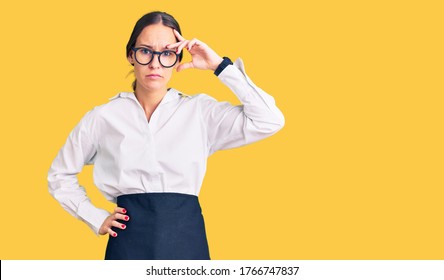 Beautiful Brunette Young Woman Wearing Professional Waitress Apron Worried And Stressed About A Problem With Hand On Forehead, Nervous And Anxious For Crisis 