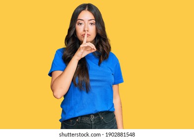 Beautiful brunette young woman wearing casual clothes asking to be quiet with finger on lips. silence and secret concept.  - Shutterstock ID 1902881548