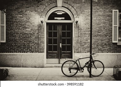 Beautiful Building. Entrance Door And Bicycle, Manhattan New York. Classic Apartment Building In New York City. Vintage, Retro Picturesque Postcard With Sepia Filter.