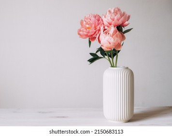 Beautiful bunch of fresh Coral Charm peonies in full bloom in vase against white background. Copy space for text. Minimalist floral still life with blooming flowers. - Shutterstock ID 2150683113