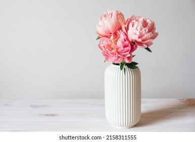 Beautiful bunch of fresh Coral Charm peonies in full bloom in vase against white background. Copy space for text. Minimalist floral still life with blooming flowers. - Powered by Shutterstock