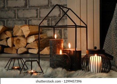 Beautiful Burning Candles On Furry Rug Near Fireplace