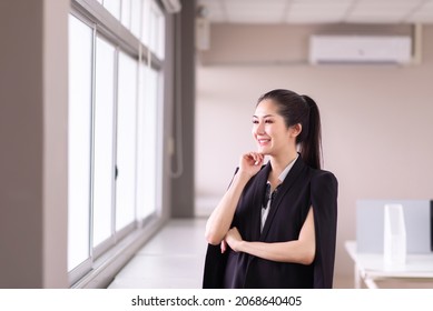 Beautiful business asian woman standing and looking on window in the office
