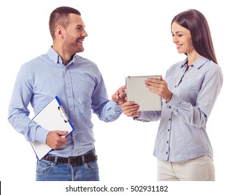 Beautiful business couple in smart casual wear is using a digital tablet, talking and smiling, isolated on white