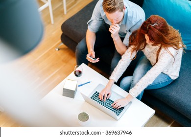 Beautiful business couple working on laptop in  modern cosy room