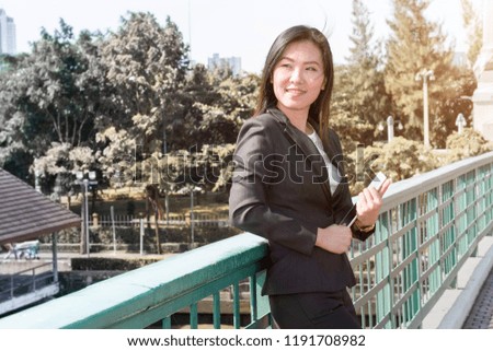 Beautiful business maneger woman smiling and thinking about success work.Lady with laptop in black suite.