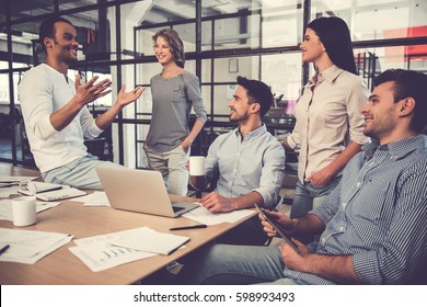 Beautiful business people are using gadgets, talking and smiling during the conference in office - Shutterstock ID 598993493