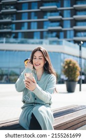 Beautiful Business Woman Enjoying Coffee Break On Free Time Outdoor With Favorite Music In Earphones, Millenial Female Listening Audio Book On Mobile App 