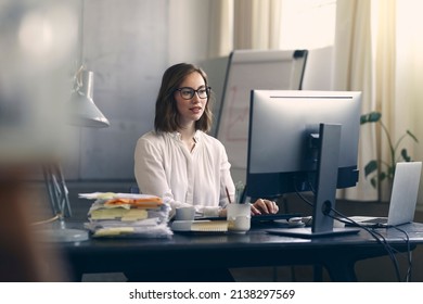 Beautiful business woman and female employee sitting concentrated about her work on the office computer at her table desk with a huge pile of paper work.	 - Shutterstock ID 2138297569