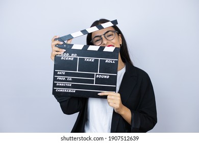 Beautiful business woman holding a clapperboard