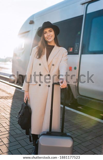 Beautiful business woman with luggage on the\
platform of the railway\
station