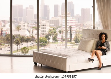 Beautiful Business Woman In A Penthouse Suite At A Hotel On Her Cell Phone