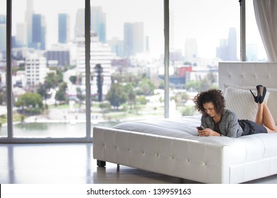 Beautiful Business Woman In A Penthouse Suite At A Hotel On Her Cell Phone