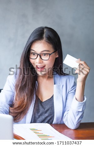 Beautiful business woman sitting at home office desk  using a laptop and smiling while working with Credit card in the hand, and and be attractive cheerful model using computer. Indoors